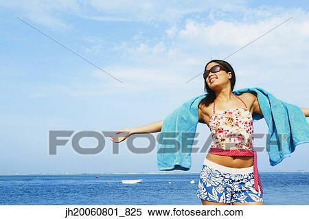 Hispanic woman with arms outstretched at beach View Large Photo Image Stock Photography - Hispanic woman with arms outstretched at beach. Fotosearch