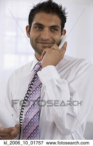 Indian businessman talking on telephone View Large Photo Image Stock Photo - Indian businessman talking on telephone. Fotosearch
