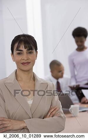 Stock Photo - Indian businesswoman with co-workers in background. Fotosearch