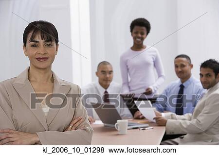 Indian businesswoman with co-workers in background View Large Photo Image Stock Photo - Indian businesswoman with co-workers in background. Fotosearch