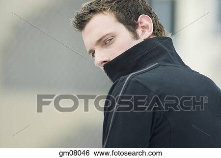 Man in sweatshirt looking over shoulder View Large Photo Image Stock Photograph - Man in sweatshirt looking over shoulder. Fotosearch