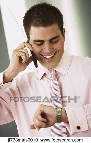 Stock Image - Middle Eastern businessman checking watch. Fotosearch