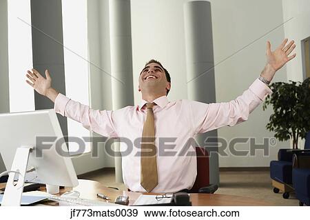 Middle Eastern businessman cheering at desk View Large Photo Image Stock Photo - Middle Eastern businessman cheering at desk. Fotosearch