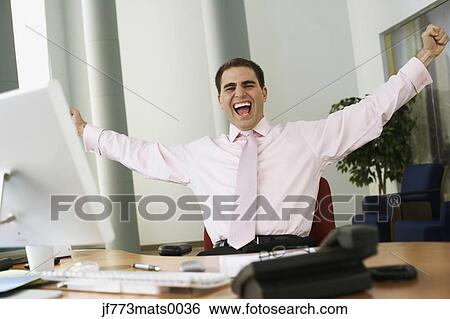 Middle Eastern businessman cheering at desk View Large Photo Image Stock Photograph - Middle Eastern businessman cheering at desk. Fotosearch