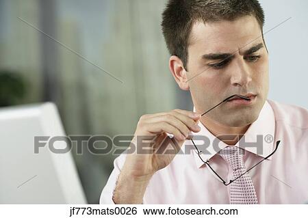 Stock Photograph - Middle Eastern businessman holding eyeglasses. Fotosearch