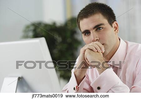 Stock Photo - Middle Eastern businessman sitting at desk. Fotosearch