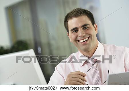 Middle Eastern businessman sitting at desk View Large Photo Image Stock Photo - Middle Eastern businessman sitting at desk. Fotosearch