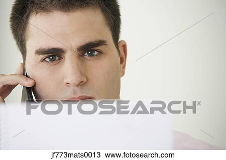 Stock Image - Middle Eastern businessman talking on cell phone. Fotosearch