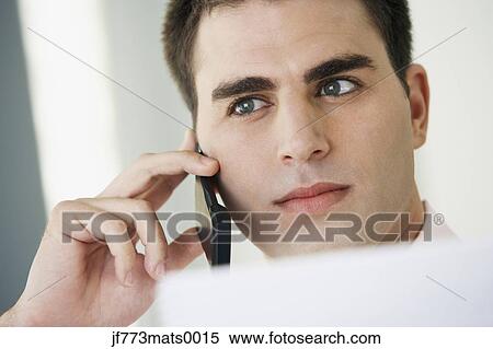 Stock Photography - Middle Eastern businessman talking on cell phone. Fotosearch