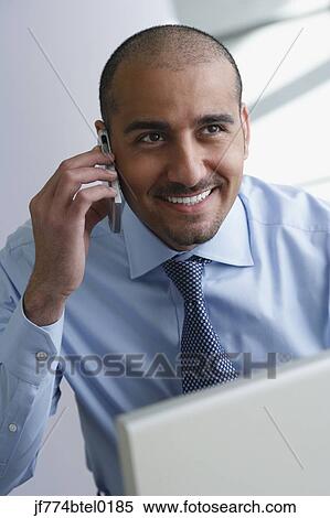 Middle Eastern businessman talking on cell phone View Large Photo Image Stock Photography - Middle Eastern businessman talking on cell phone. Fotosearch