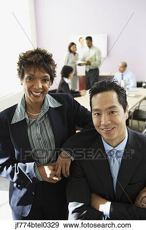 Stock Photo - Multi-ethic businesspeople in conference room. Fotosearch