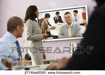 Multi-ethnic businesspeople having video conference View Large Photo Image Stock Image - Multi-ethnic businesspeople having video conference. Fotosearch