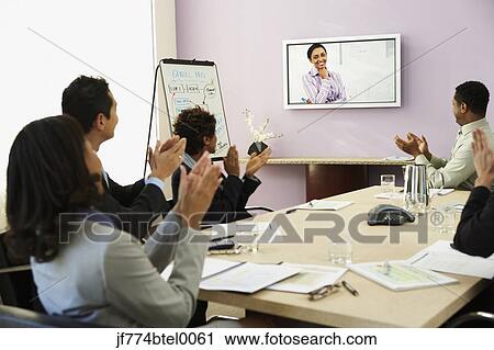 Stock Image - Multi-ethnic businesspeople having video conference. Fotosearch