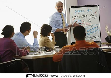 Stock Image - Multi-ethnic businesspeople having meeting. Fotosearch