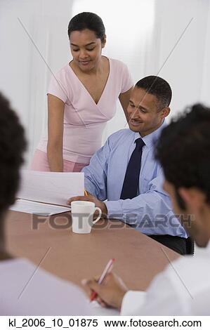 Multi-ethnic businesspeople looking at paperwork View Large Photo Image Stock Photography - Multi-ethnic businesspeople looking at paperwork. Fotosearch