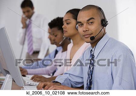 Multi-ethnic businesspeople working at computers View Large Photo Image Stock Photo - Multi-ethnic businesspeople working at computers. Fotosearch