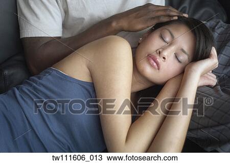 Multi-ethnic couple cuddling on sofa View Large Photo Image Stock Image - Multi-ethnic couple cuddling on sofa. Fotosearch