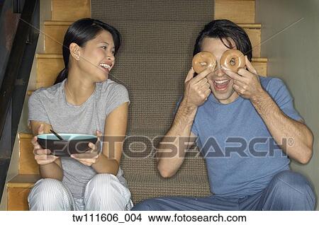 Multi-ethnic couple joking around on stairs View Large Photo Image Picture - Multi-ethnic couple joking around on stairs. Fotosearch