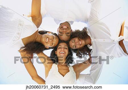 Stock Photography - Multi-ethnic friends in huddle. Fotosearch