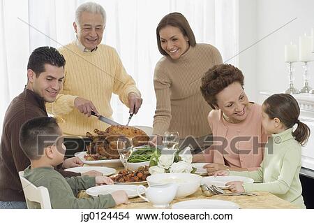 Multi-generational Hispanic family eating at Thanksgiving table View Large Photo Image Picture - Multi-generational Hispanic family eating at Thanksgiving table. Fotosearch