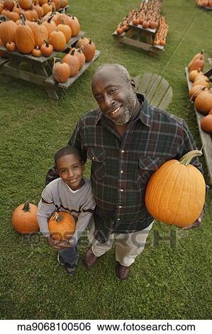 Portrait of African father and son holding pumpkins View Large Photo Image Stock Photograph - Portrait of African father and son holding pumpkins. Fotosearch