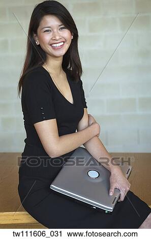 Portrait of Asian businesswoman holding laptop View Large Photo Image Stock Image - Portrait of Asian businesswoman holding laptop. Fotosearch