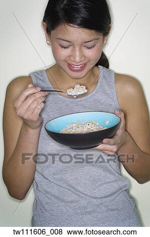 Stock Photo - Portrait of Asian woman eating cereal. Fotosearch