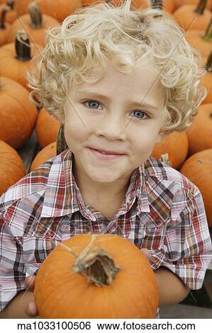 Stock Photograph - Portrait of boy holding pumpkin. Fotosearch