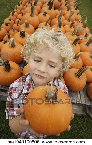 Portrait of boy holding pumpkin View Large Photo Image Stock Photograph - Portrait of boy holding pumpkin. Fotosearch