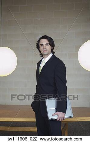 Portrait of businessman carrying laptop View Large Photo Image Stock Image - Portrait of businessman carrying laptop. Fotosearch