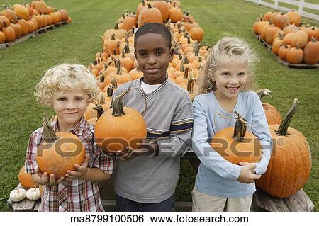 Portrait of children holding pumpkins View Large Photo Image Stock Photograph - Portrait of children holding pumpkins. Fotosearch