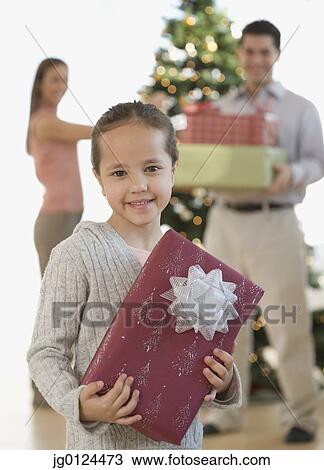 Portrait of Hispanic girl holding Christmas gift View Large Photo Image Stock Image - Portrait of Hispanic girl holding Christmas gift. Fotosearch