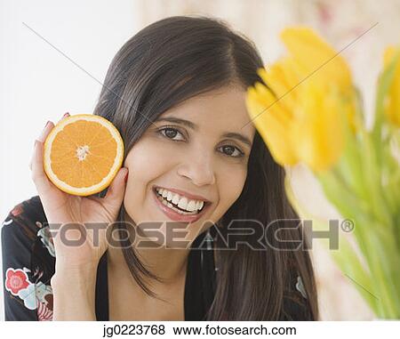 Portrait of Hispanic woman holding orange View Large Photo Image Stock Photo - Portrait of Hispanic woman holding orange. Fotosearch