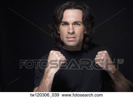 Stock Photo - Portrait of man holding fists up. Fotosearch
