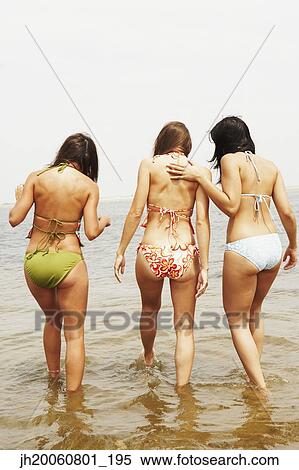 Rear view of three women at beach View Large Photo Image Stock Photography - Rear view of three women at beach. Fotosearch