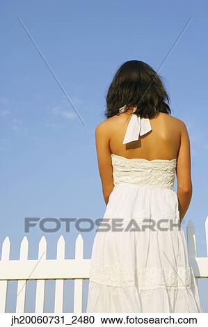 Rear view of woman next to fence View Large Photo Image Stock Image - Rear view of woman next to fence. Fotosearch