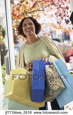 Senior African woman carrying shopping bags View Large Photo Image Stock Photo - Senior African woman carrying shopping bags. Fotosearch