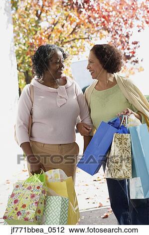 Stock Image - Senior African women carrying shopping bags. Fotosearch