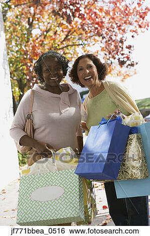 Stock Photograph - Senior African women carrying shopping bags. Fotosearch