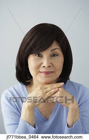 Senior Asian woman resting chin on hands View Large Photo Image Picture - Senior Asian woman resting chin on hands. Fotosearch