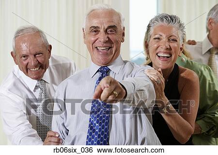 Stock Photograph - Senior couple at party pointing in surprise. Fotosearch