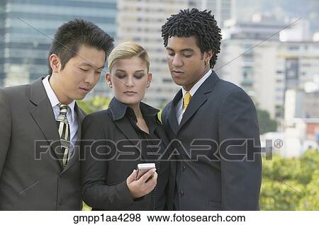 Stock Photo - Three businesspeople looking at cell phone. Fotosearch