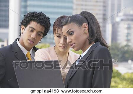 Three businesspeople looking at laptop View Large Photo Image Stock Image - Three businesspeople looking at laptop. Fotosearch