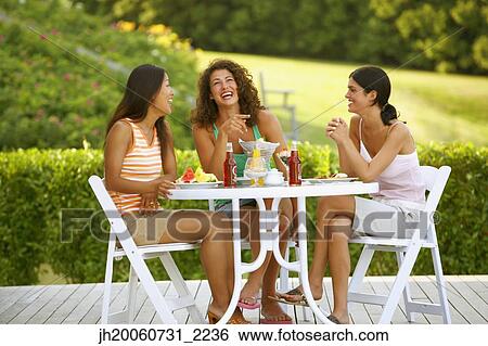 Three women eating on patio View Large Photo Image Stock Photograph - Three women eating on patio. Fotosearch