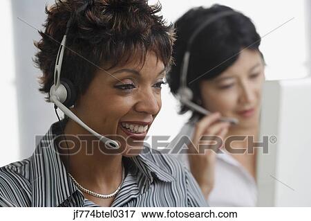 Two businesswomen wearing headsets View Large Photo Image Stock Photo - Two businesswomen wearing headsets. Fotosearch