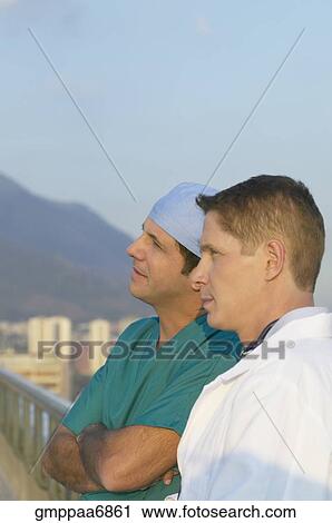 Stock Image - Two male doctors on balcony. Fotosearch