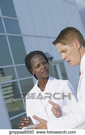 Stock Image - Two medical professionals discussing chart. Fotosearch