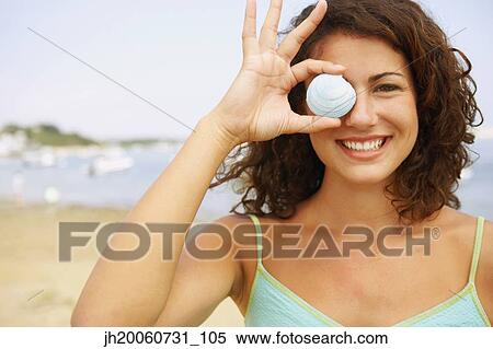Woman holding seashell over eye View Large Photo Image Stock Photography - Woman holding seashell over eye. Fotosearch