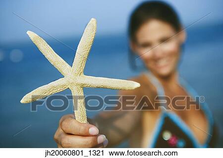 Woman holding up starfish View Large Photo Image Stock Image - Woman holding up starfish. Fotosearch