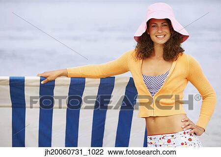 Woman leaning on sun shade at beach View Large Photo Image Stock Image - Woman leaning on sun shade at beach. Fotosearch